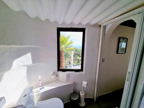 a white bathroom with a tub and a window at Etoile arc-en-ciel in Tejina de Isora