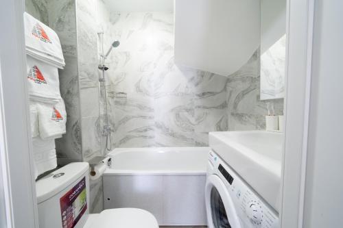 bagno con lavandino e servizi igienici e lavatrice. di MYFREEDOM Апартаменти метро Нивки a Kiev