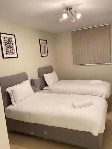 a bedroom with two beds and a window at Next-Stop Haven in Harlow