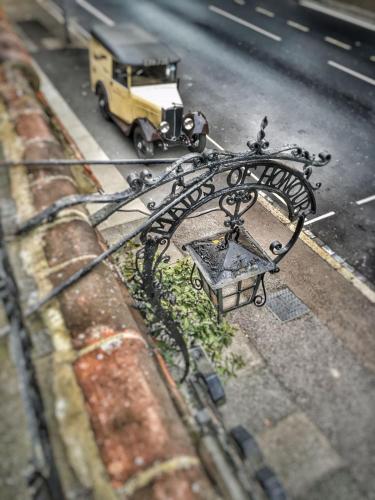a view of a street with a bench and a car at Maids Guest Rooms in Kew