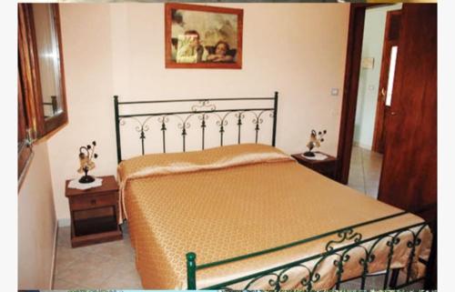 a bedroom with a bed and two tables and a picture at B&B IL PALOMBARO in Uggiano la Chiesa