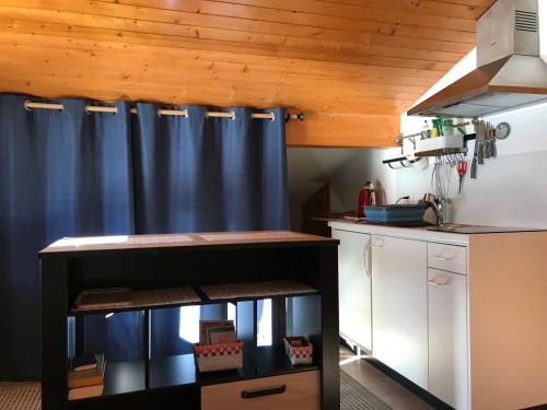eine Küche mit einem blauen Vorhang und einer Theke in der Unterkunft Becca Miedzo appartement in Le Châble