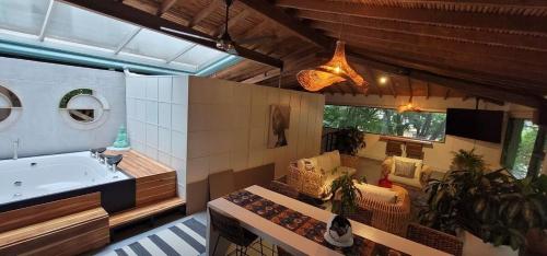 a bathroom with a tub and a couch and a sink at Vintage House With Jacuzzi In Manila in Medellín