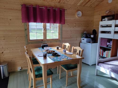 una cocina con mesa y sillas en una cabaña en Satukurki-vierasmaja - Simple and Cute Cabin, en Sastamala