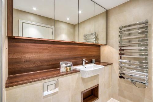 a bathroom with a sink and a mirror at Contemporary and Stylish 2 Bed in Nine Elms in London