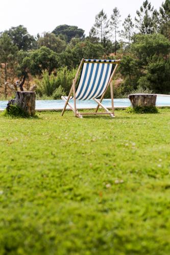 a blue and white chair sitting in the grass at Monte Do Areeiro in Coruche