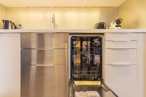 a dishwasher with its door open in a kitchen at Wonder Appart' 402 - Vue sur Garonne in Toulouse