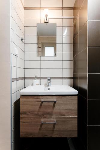 a bathroom with a sink and a mirror at Our House Luxury Suites in Paleo Tsifliki