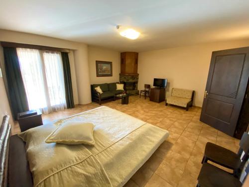 a bedroom with a large bed and a living room at Le Chalet in Xanthi