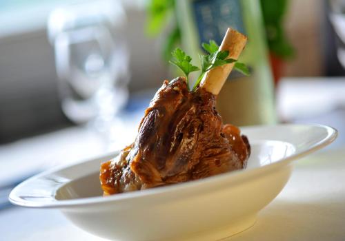 a piece of meat on a plate on a table at Aparthotel Stare Miasto in Kraków