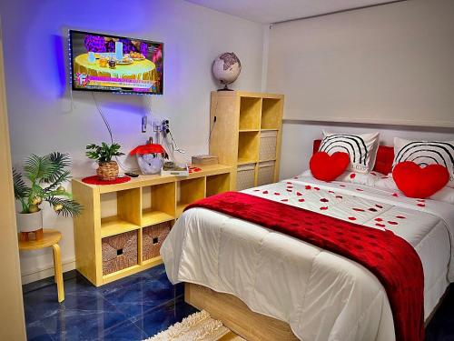 a bedroom with a bed with red pillows and a tv at Blue Salou in Salou