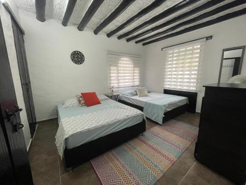 a room with two beds and two windows at Casa de Descanso in Melgar