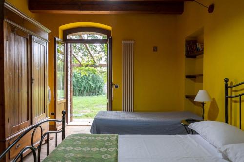 a bedroom with two beds and a large window at Agriturismo Dai Mori in Isola del Piano
