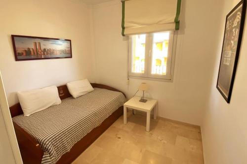 een kleine slaapkamer met een bed en een raam bij Novo Sancti Petri, La Barrosa, 2 Beds Room Apartamento by Chiclana Dreams in Chiclana de la Frontera