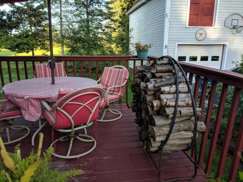 a deck with a table and chairs and a fire place at Baylies Home in Tully