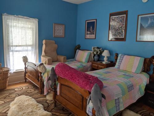 a bedroom with two beds and a chair at Baylies Home in Tully