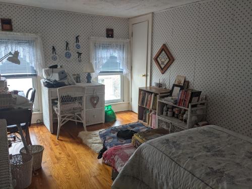 Tully的住宿－Baylies Home，一间卧室配有一张床、一张桌子和一个窗户。