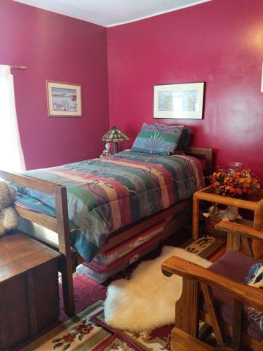 Tully的住宿－Baylies Home，一间卧室配有一张床和紫色的墙壁