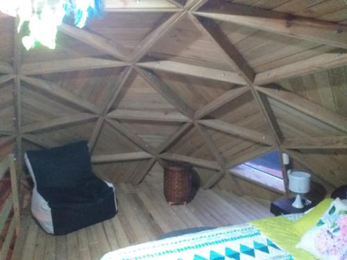 an attic room with a chair and a window at Unique Glamping / Domo Betsaida in Guatapé