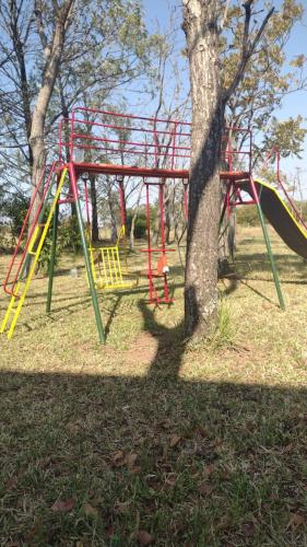 un parque infantil con un tobogán rojo y amarillo en un parque en Carmen del Paraná Sandra Hostel en Carmen del Paraná