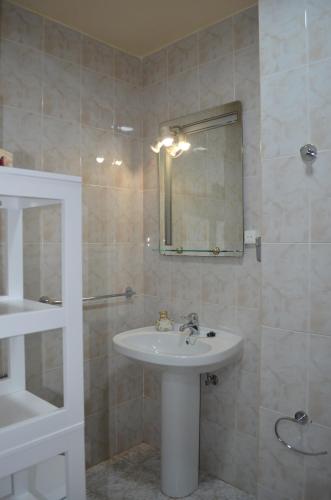 ein Bad mit einem Waschbecken und einem Spiegel in der Unterkunft Piso en Urbanización Villarchao in O Grove