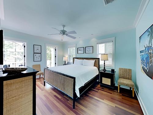 1 dormitorio con cama blanca y pared azul en Watercolor Whimsea, en Seagrove Beach