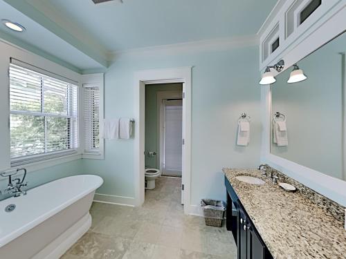 a bathroom with a tub and a sink at Watercolor Whimsea in Seagrove Beach