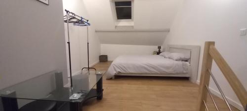une chambre avec un lit et une table en verre dans l'établissement Le cottage du village, à Seigny