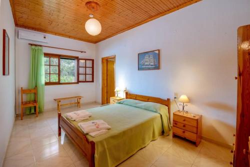 a bedroom with a bed and a wooden ceiling at Olive Tree Villa in Ieromónachos