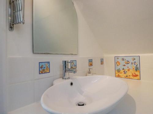 La salle de bains est pourvue d'un lavabo blanc et d'un miroir. dans l'établissement Sea View, à Mevagissey