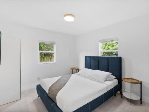 戴維的住宿－New Villa, Pool, Near Hard Rock 4BR3，一间卧室设有蓝色的床和2个窗户。