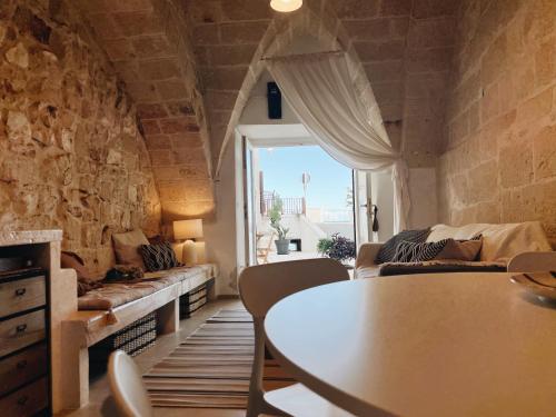 a living room with a table and a large window at CASA NAUTILO - Porta Vecchia in Monopoli