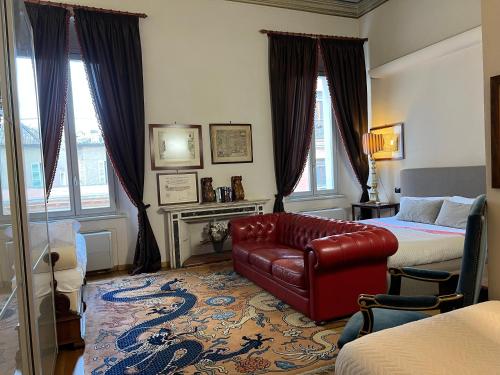 a bedroom with a red leather couch and a bed at A Casa Di Paola Suite in Ravenna