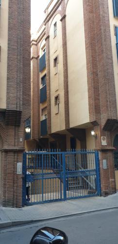 a blue fence in front of a building at Apartamentos Maria Cristina in Córdoba