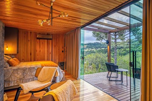 een slaapkamer met een bed en een balkon met uitzicht bij Refúgio de Altitude in Urupema