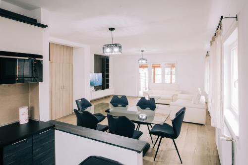 a kitchen and living room with a table and chairs at Tulip Guest House I. in Palić