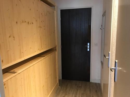 - un couloir avec une porte noire et du parquet dans l'établissement Studio rénové à Tignes, proche pistes, wifi gratuit - FR-1-449-1, à Tignes
