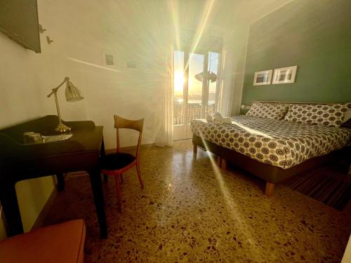 a bedroom with a bed and a desk and a window at Garibaldi R&B in Messina