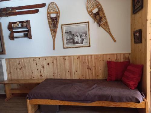 ティーニュにあるAppartement Tignes, 2 pièces, 5 personnes - FR-1-449-159のベッドルーム1室(木製ベッド1台、赤い枕2つ付)