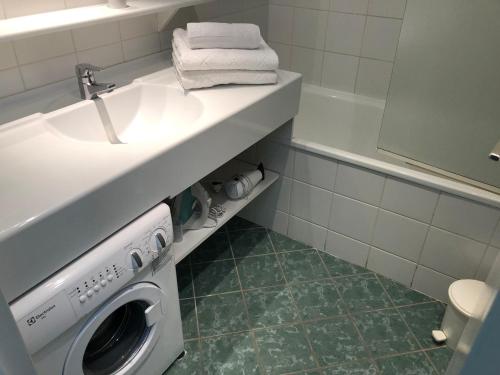ein Badezimmer mit einer Waschmaschine unter einem Waschbecken in der Unterkunft Studio Tignes, 1 pièce, 4 personnes - FR-1-449-165 in Tignes
