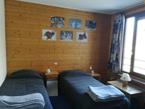 ティーニュにあるAppartement Tignes, 2 pièces, 4 personnes - FR-1-449-170のベッドルーム1室(ベッド2台付)が備わります。壁には絵画が飾られています。