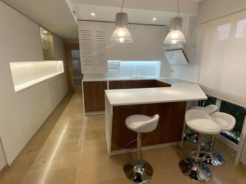 una cocina con barra y dos taburetes. en Acogedor apartamento con acabados primera calidad, en Zaragoza