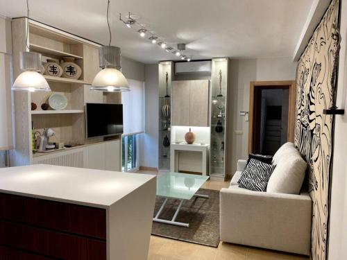 cocina y sala de estar con sofá y mesa en Acogedor apartamento con acabados primera calidad, en Zaragoza