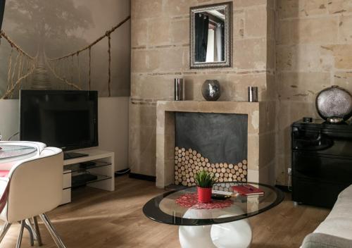 een woonkamer met een open haard en een televisie bij "L'Appart" Vieux Tours - Charme - Place Plumereau - Arrivée Autonome in Tours