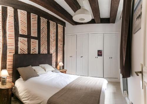 a bedroom with a bed and a brick wall at "L'Appart" Vieux Tours - Charme - Place Plumereau - Arrivée Autonome in Tours