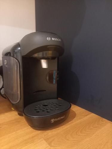 a black coffee maker sitting on a wooden table at Sunny Side - Self Catering Accommodation Gorey in Gorey