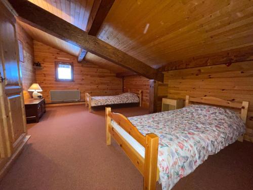 une chambre avec un lit dans une cabane en rondins dans l'établissement Duplex spacieux 3 pièces 6 pers. Les Carroz, parking et cheminée - FR-1-572-152, à Arâches-la-Frasse