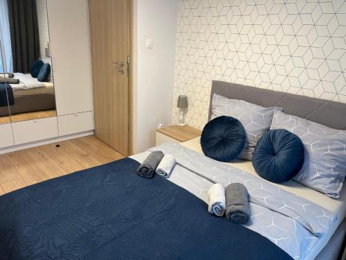 um quarto com uma cama com almofadas azuis em Rakowicka Modern Apartment na Cracóvia