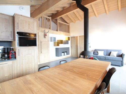 une cuisine et une salle à manger avec une table en bois dans l'établissement Appartement 3P cosy, cheminée, WIFI, garage, proche pistes et commerces - FR-1-572-240, aux Carroz d'Arâches