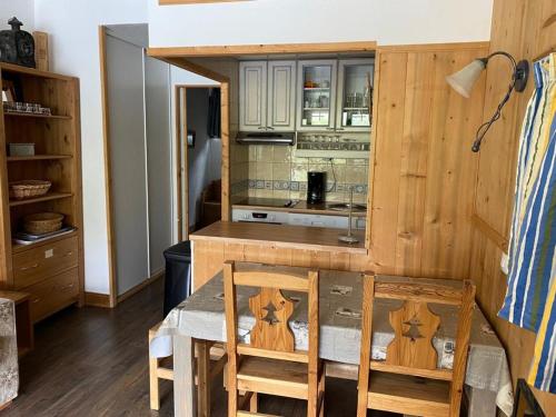 une cuisine avec une table en bois et deux chaises dans l'établissement T2 Sud/Ouest avec Balcon - Tignes - FR-1-449-181, à Tignes